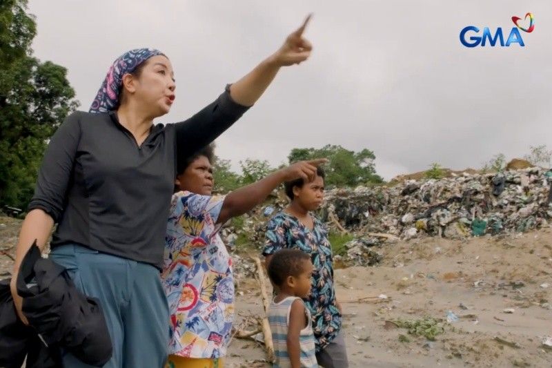 Kara David and Aeta community members looking across accumulated waste at the Subic site